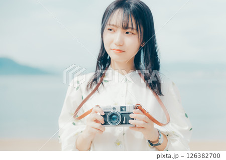 砂浜でフィルムカメラを構える少女 126382700