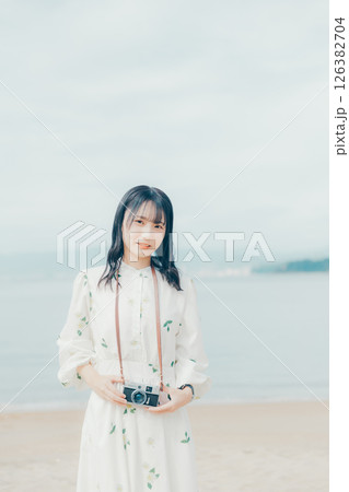 砂浜でフィルムカメラを構える少女 126382704