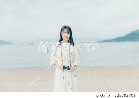 砂浜でフィルムカメラを構える少女 126382705