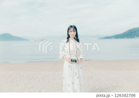 砂浜でフィルムカメラを構える少女 砂浜でフィルムカメラを構える少女 126382706