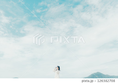 砂浜でフィルムカメラを構える少女 砂浜でフィルムカメラを構える少女 126382708