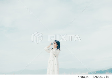 砂浜でフィルムカメラを構える少女 126382710