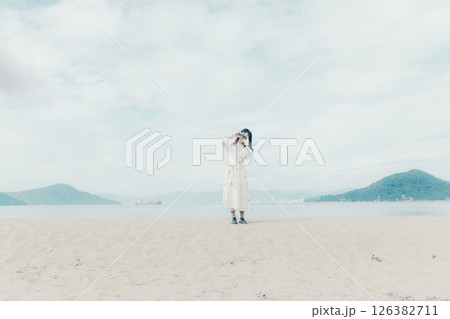 砂浜でフィルムカメラを構える少女 砂浜でフィルムカメラを構える少女 126382711