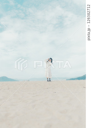 砂浜でフィルムカメラを構える少女 126382712