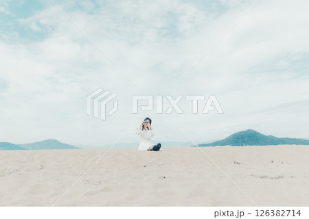 砂浜でフィルムカメラを構える少女 126382714