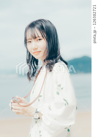 砂浜でフィルムカメラを構える少女 砂浜でフィルムカメラを構える少女 126382721