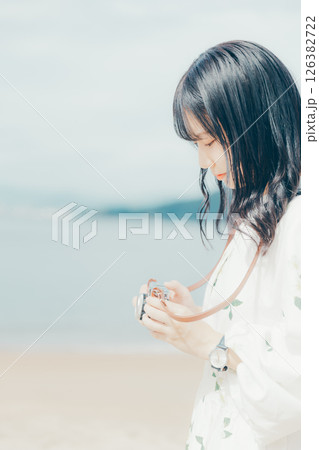 砂浜でフィルムカメラを構える少女 砂浜でフィルムカメラを構える少女 126382722