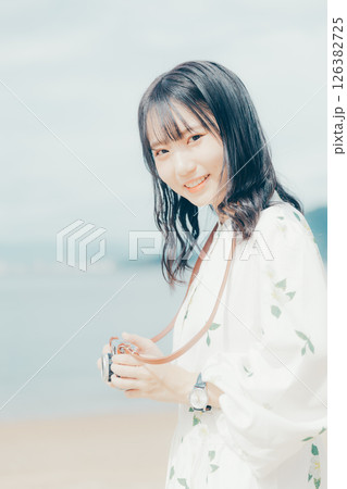 砂浜でフィルムカメラを構える少女 砂浜でフィルムカメラを構える少女 126382725