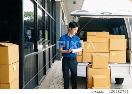 Asian courier delivery man searching the address on digital tablet. near van outside the warehouse. This is a freight transportation Asian courier delivery man searching the address on digital tablet. near van outside the warehouse. This is a freight transportation 126382761
