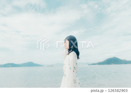 海辺に立つナチュラルな装いの若い女性 海辺に立つナチュラルな装いの若い女性 126382903