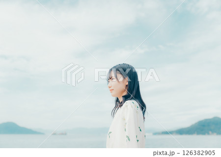 海辺に立つナチュラルな装いの若い女性 海辺に立つナチュラルな装いの若い女性 126382905