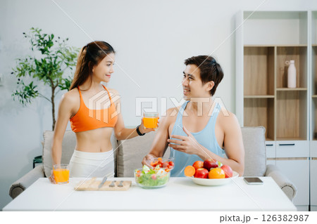 Fitness duo celebrating healthy living with fresh salad, fruits, and juice. A perfect balance of wellness, nutrition Fitness duo celebrating healthy living with fresh salad, fruits, and juice. A perfect balance of wellness, nutrition 126382987