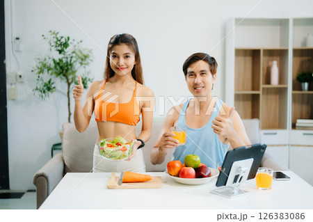 Fitness duo celebrating healthy living with fresh salad, fruits, and juice. A perfect balance of wellness, nutrition Fitness duo celebrating healthy living with fresh salad, fruits, and juice. A perfect balance of wellness, nutrition 126383086