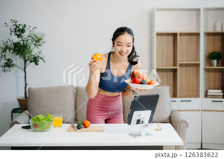 Woman enjoys a fresh salad with fruits and juice, embodying wellness, nutrition, and vitality Woman enjoys a fresh salad with fruits and juice, embodying wellness, nutrition, and vitality 126383622