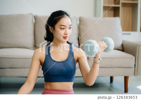 A young woman practices yoga and stretching with a mat and gym props, showcasing wellness, motivation, A young woman practices yoga and stretching with a mat and gym props, showcasing wellness, motivation, 126383653