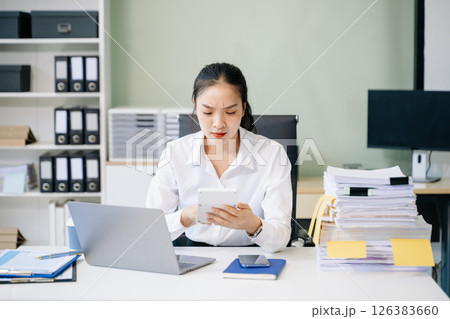 Young beautiful woman using laptop and tablet while sitting at her working place. 126383660