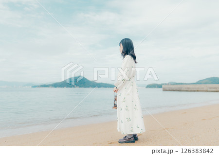 穏やかな海とランタンを手にした女性の後ろ姿 126383842