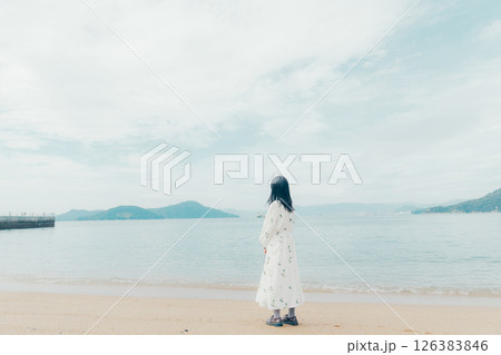 穏やかな海とランタンを手にした女性の後ろ姿 126383846