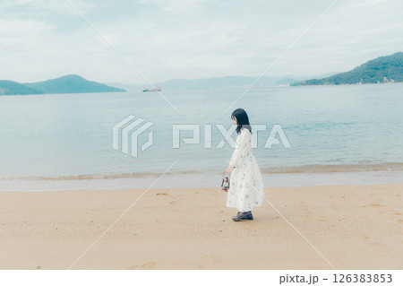 穏やかな海とランタンを手にした女性の後ろ姿 穏やかな海とランタンを手にした女性の後ろ姿 126383853