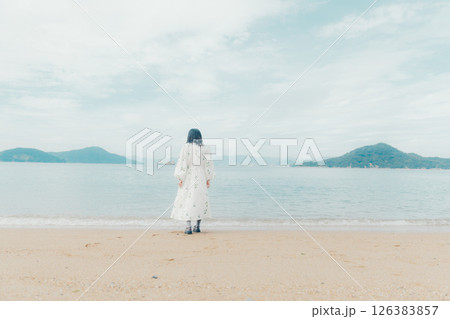 穏やかな海とランタンを手にした女性の後ろ姿 126383857