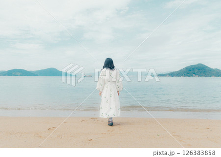 穏やかな海とランタンを手にした女性の後ろ姿 126383858