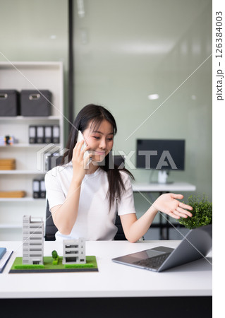 Real estate broker agent presenting and consult to customer to decision making sign insurance form agreement, home model, concerning mortgage loan offer 126384003