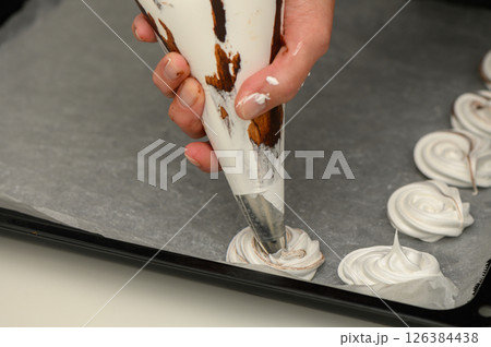 Mastering the art of meringue with swirls of chocolate on parchment 126384438
