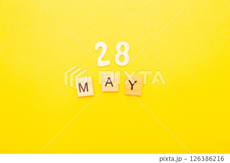 Top view of word 28 May calendar date made by wooden cubes on yellow color background Top view of word 28 May calendar date made by wooden cubes on yellow color background 126386216