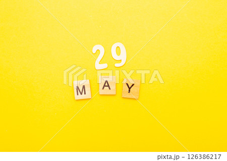 Top view of word 29 May calendar date made by wooden cubes on yellow color background 126386217