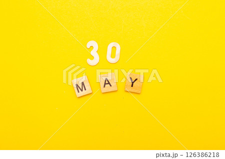 Top view of word 30 May calendar date made by wooden cubes on yellow color background Top view of word 30 May calendar date made by wooden cubes on yellow color background 126386218