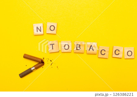 Top view of broken cigarette with the word no tabaco on a yellow background closeup 126386221