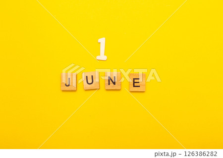 Top view of word June month made by wooden cubes with letters on a yellow bright background Top view of word June month made by wooden cubes with letters on a yellow bright background 126386282