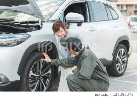 ロードサービスに駆けつけた作業員の男性とドライバーの女性 126386379