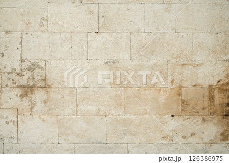 Antique ancient stone wall masonry texture background. Old wall made of beige stone blocks  126386975
