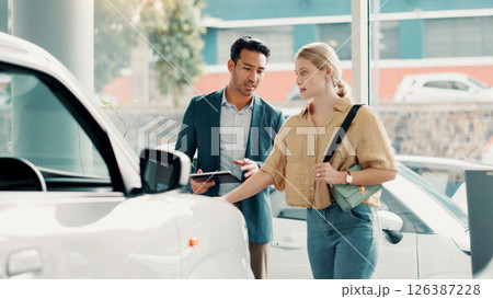 Tablet, customer and salesman with pitch for car dealership, transport model and motor for rental service. Showroom, woman and male seller with tech for assistance, vehicle features and communication 126387228