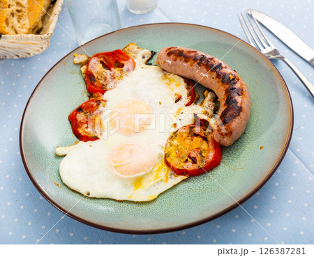 Breakfast from sunny-side-up eggs with sausages and tomatoes 126387281