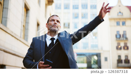 Businessman, phone and calling taxi in city for cab ride, transportation service or travel. Man, employee or traveler hailing with mobile smartphone or app for lift or local commute in an urban town 126387318