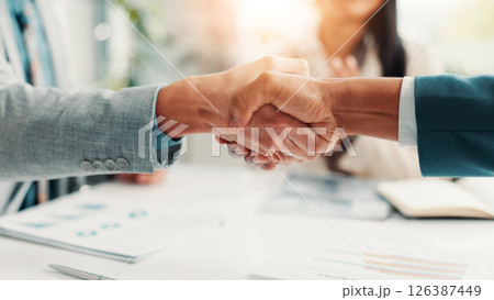 Shaking hands, paperwork and business people in office with meeting for deal, agreement or partnership. Corporate, documents and finance manager with client for handshake on investment contract. Shaking hands, paperwork and business people in office with meeting for deal, agreement or partnership. Corporate, documents and finance manager with client for handshake on investment contract. 126387449