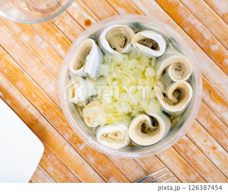 Pieces of pickled herring served with onions 126387454