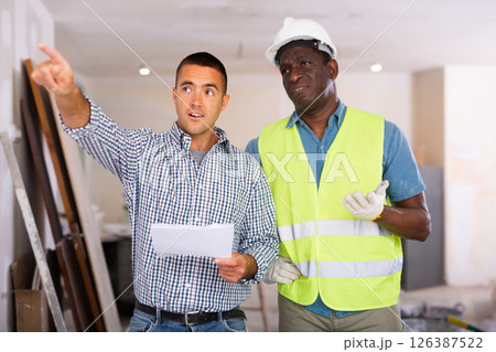 Owner of apartment discusses with foreman where and what to repair 126387522