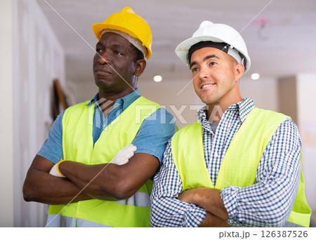 Portrait of two professional builders doing finishing work at cottage Portrait of two professional builders doing finishing work at cottage 126387526