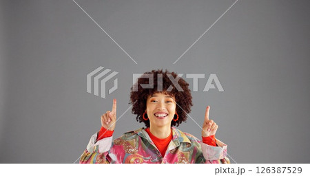 Portrait, happy woman and pointing up for advertising fashion, mockup info and discount deal. African person, marketing and show space for retro sales, promotion and offer on gray studio background Portrait, happy woman and pointing up for advertising fashion, mockup info and discount deal. African person, marketing and show space for retro sales, promotion and offer on gray studio background 126387529