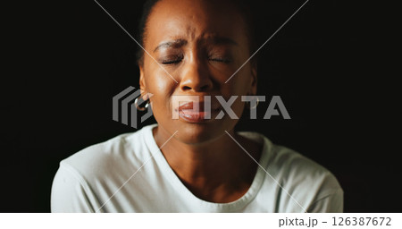 Closed eyes, sad and black woman in studio, crying and mental health on dark background. African person, mockup space or model with tears, anxiety and depression with grief, upset or stress with loss Closed eyes, sad and black woman in studio, crying and mental health on dark background. African person, mockup space or model with tears, anxiety and depression with grief, upset or stress with loss 126387672