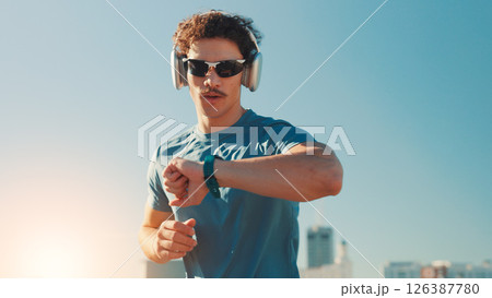 Man, fitness and checking watch with headphones in city for workout app or tracking performance. Active, male person or runner with wristwatch for music, calories or running exercise on space in town Man, fitness and checking watch with headphones in city for workout app or tracking performance. Active, male person or runner with wristwatch for music, calories or running exercise on space in town 126387780