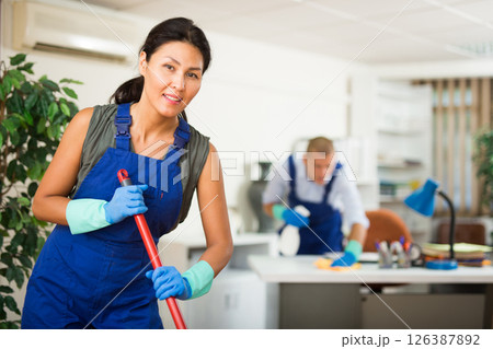 Woman wiping office floor with mop Woman wiping office floor with mop 126387892