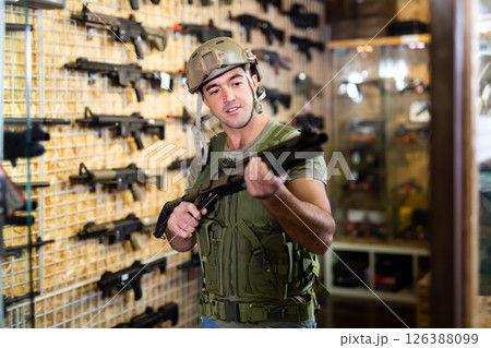 Guy in military equipment with weapon in army shop Guy in military equipment with weapon in army shop 126388099