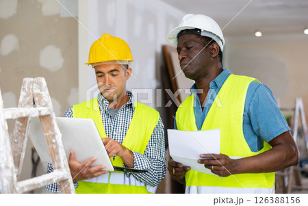 Man and man builders discussing project documentation 126388156