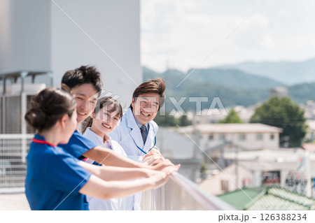 病院の屋上で休憩時間を過ごす男女の医師・医者・看護師・医療従事者・技師（4人） 126388234