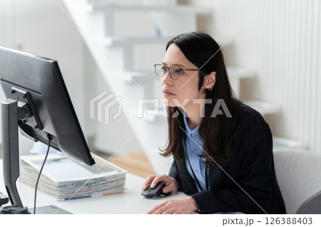 建設関連の資料を広げ仕事をする女性 126388403
