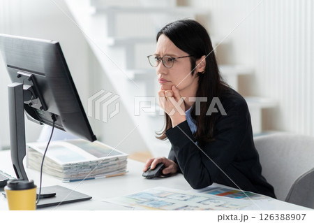 モニターを見つめて困った様子の女性デザイナー モニターを見つめて困った様子の女性デザイナー 126388907